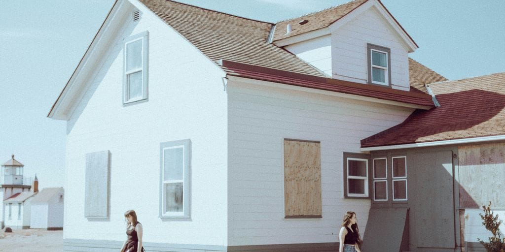 a couple of people standing in front of a house